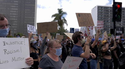 a group of people holding signs and wearing masks