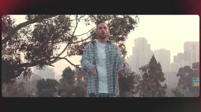 a man standing in front of a tree with a city in the background