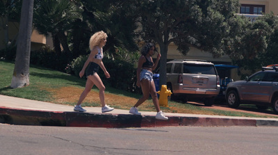 two women walking down the street near a fire hydrant