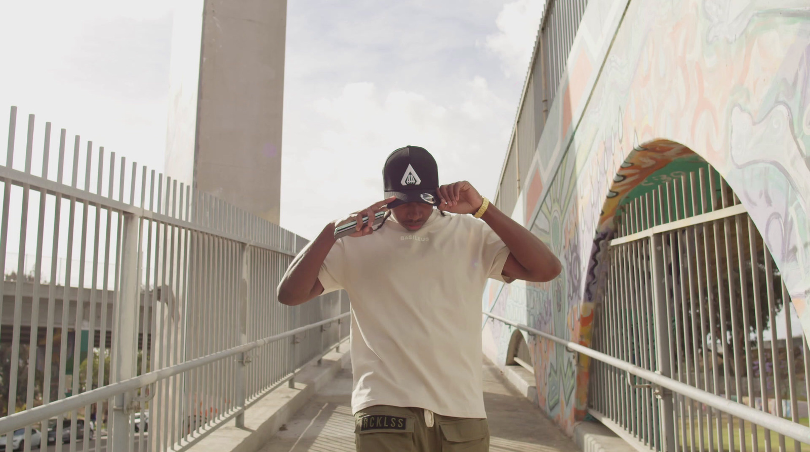 a man walking down a sidewalk while wearing a hat