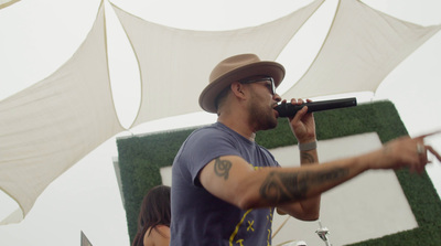 a man in a fedora singing into a microphone