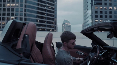 a man sitting in a sports car in a city