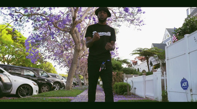 a man standing on a sidewalk with a skateboard