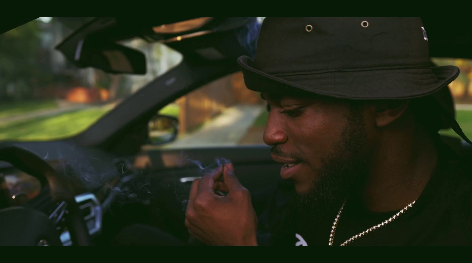 a man sitting in a car smoking a cigarette