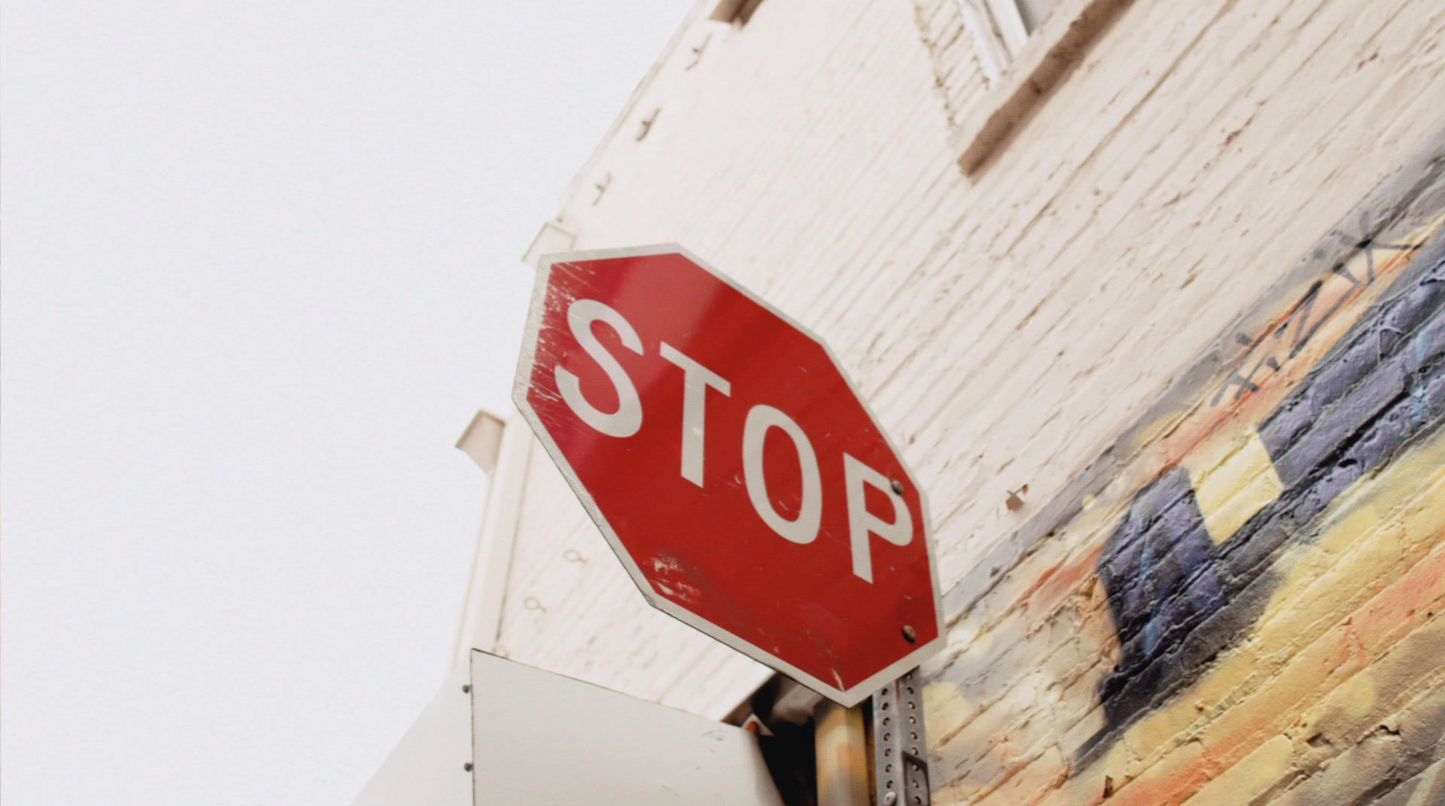 a red stop sign mounted to the side of a building