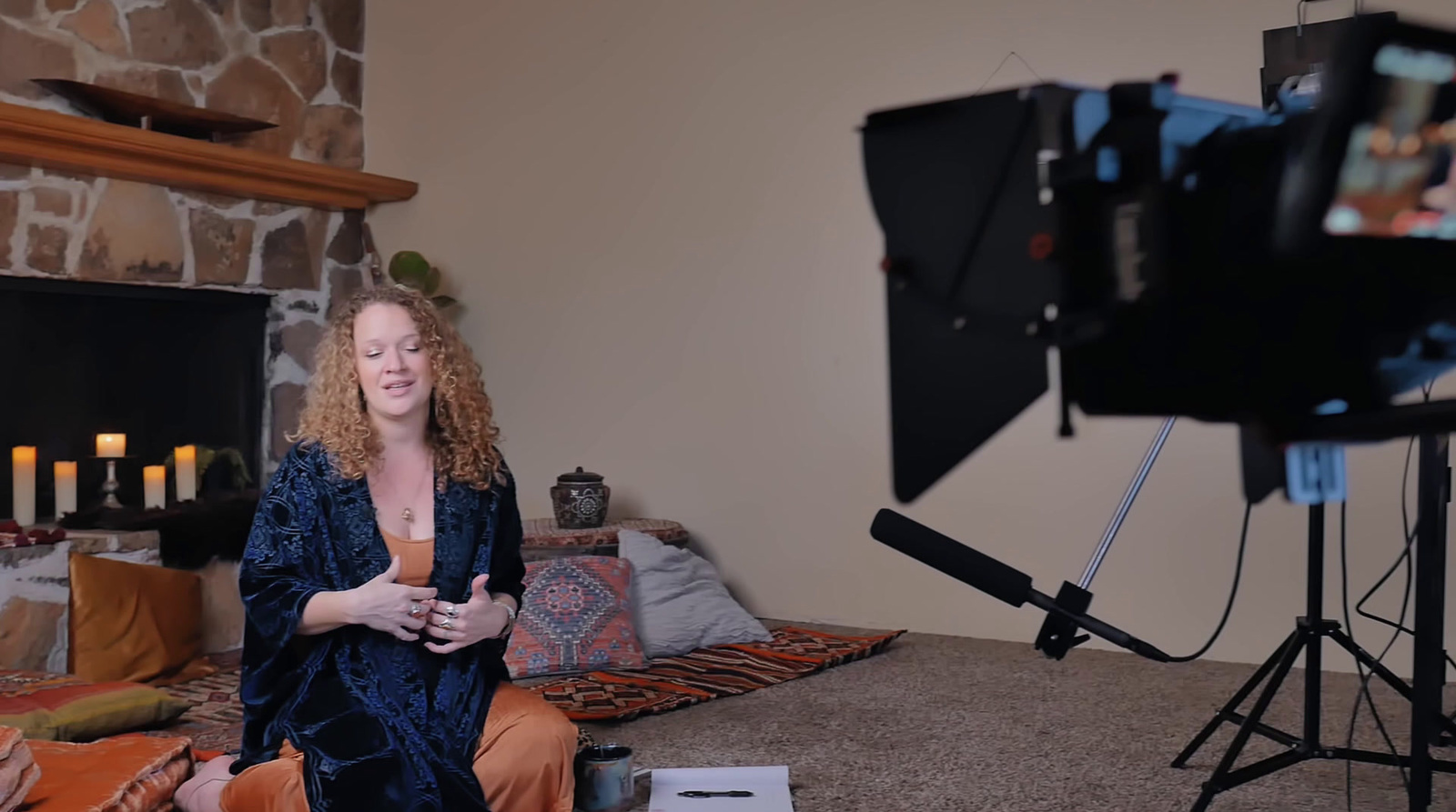 a woman sitting on the floor in front of a camera