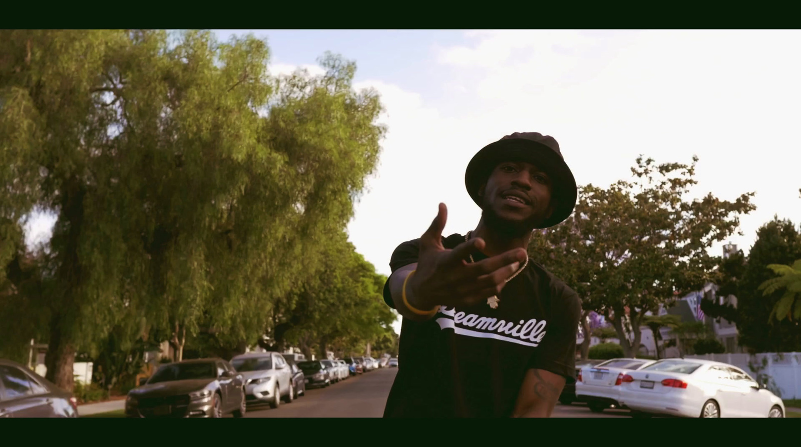 a man in a black shirt and hat pointing at something