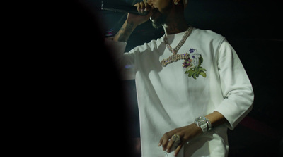 a male in a white shirt and a microphone