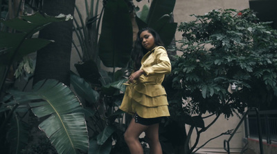 a woman in a yellow jacket and black shorts