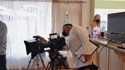 a man standing in front of a camera on a tripod