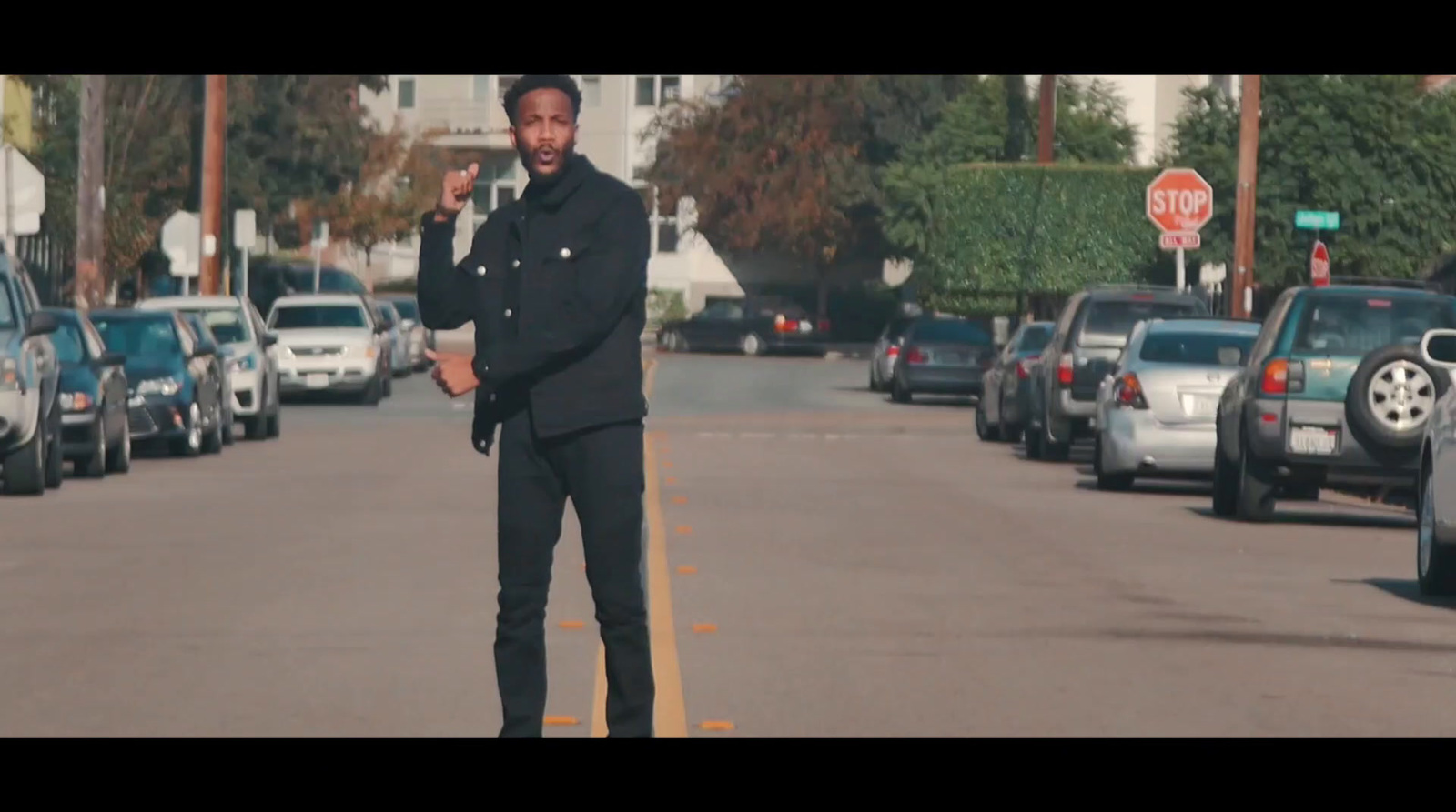 a man standing in the middle of a street talking on a cell phone