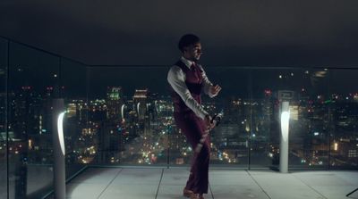 a man in a suit and tie standing on a balcony