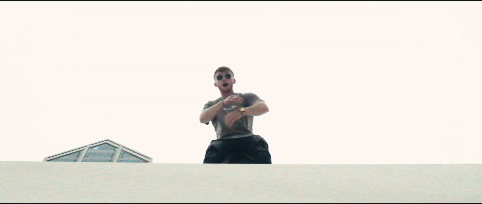 a man standing on top of a roof holding a frisbee