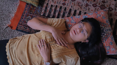 a woman laying on the floor with her arm around her chest