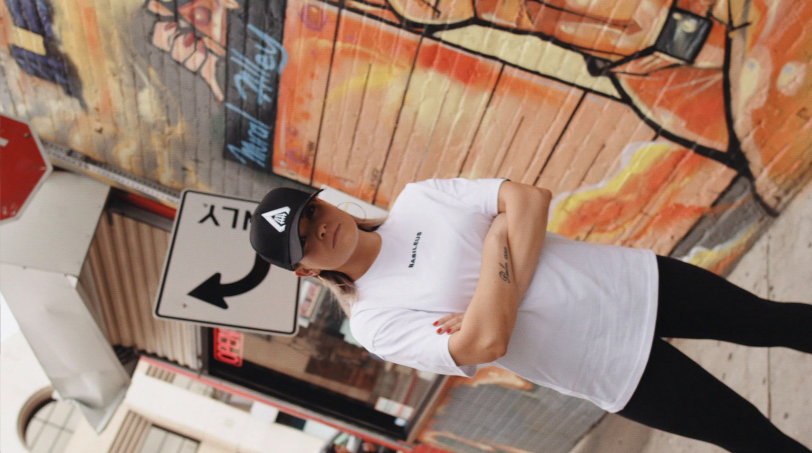 a man in white shirt and black pants standing next to a street sign