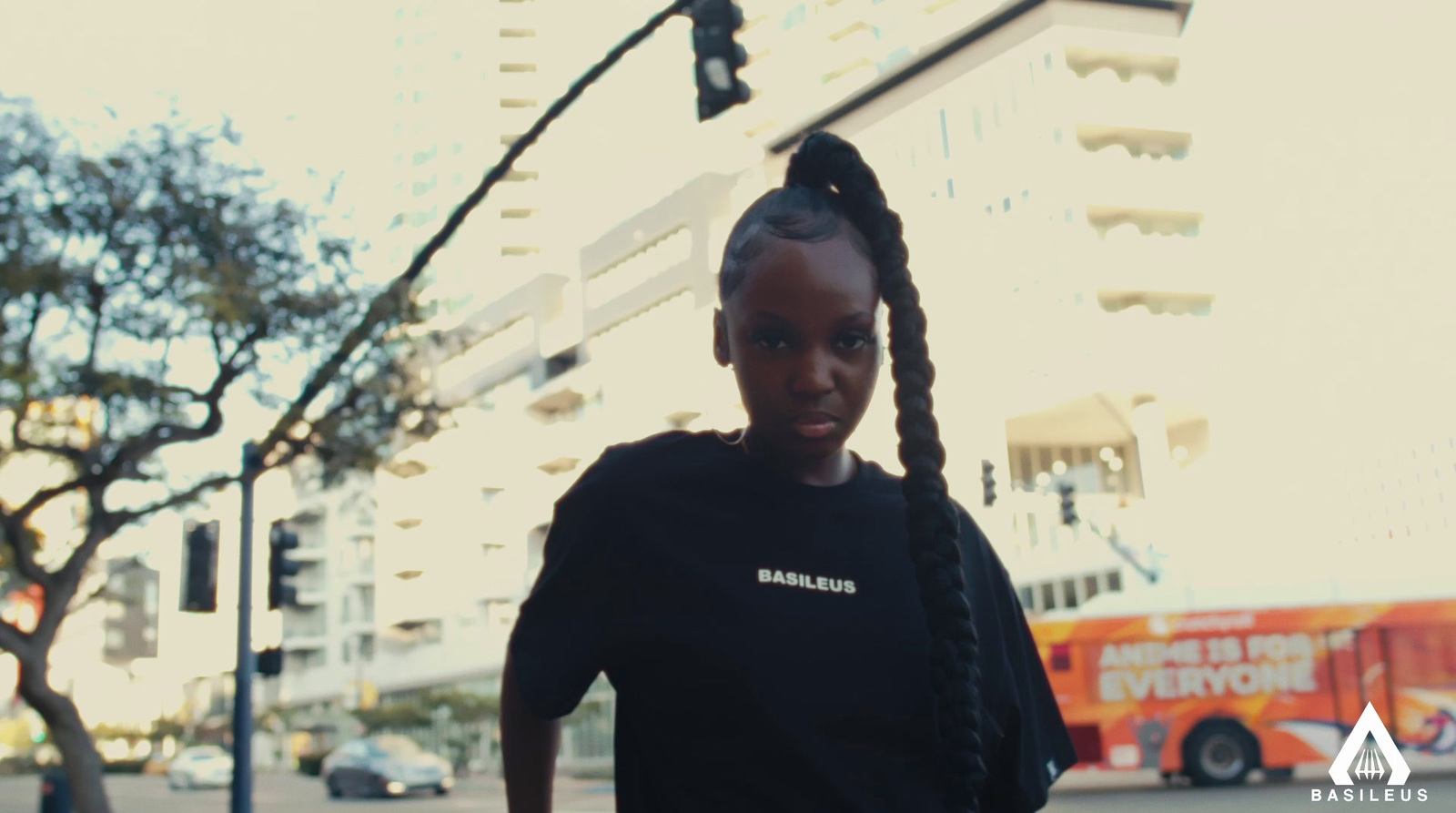 a girl with braids standing on a street corner