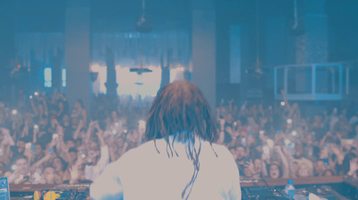 a dj in front of a large crowd at a concert