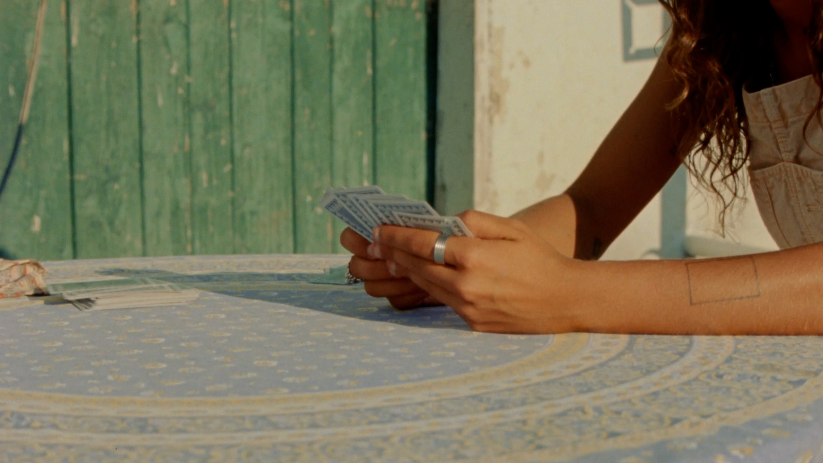 a woman sitting at a table holding a cell phone