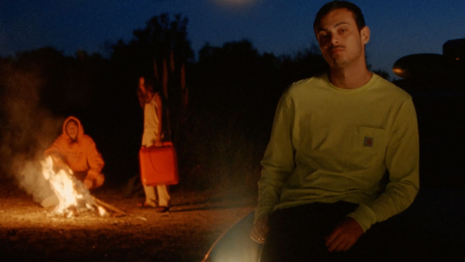 a man and a woman sitting next to a fire