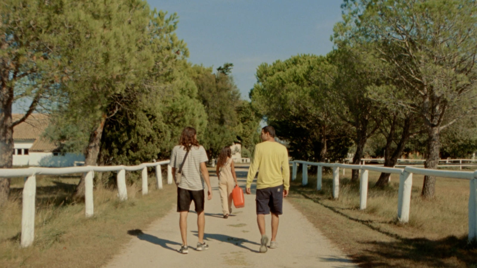 a couple of people walking down a dirt road