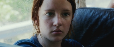 a young girl with red hair sitting in a car