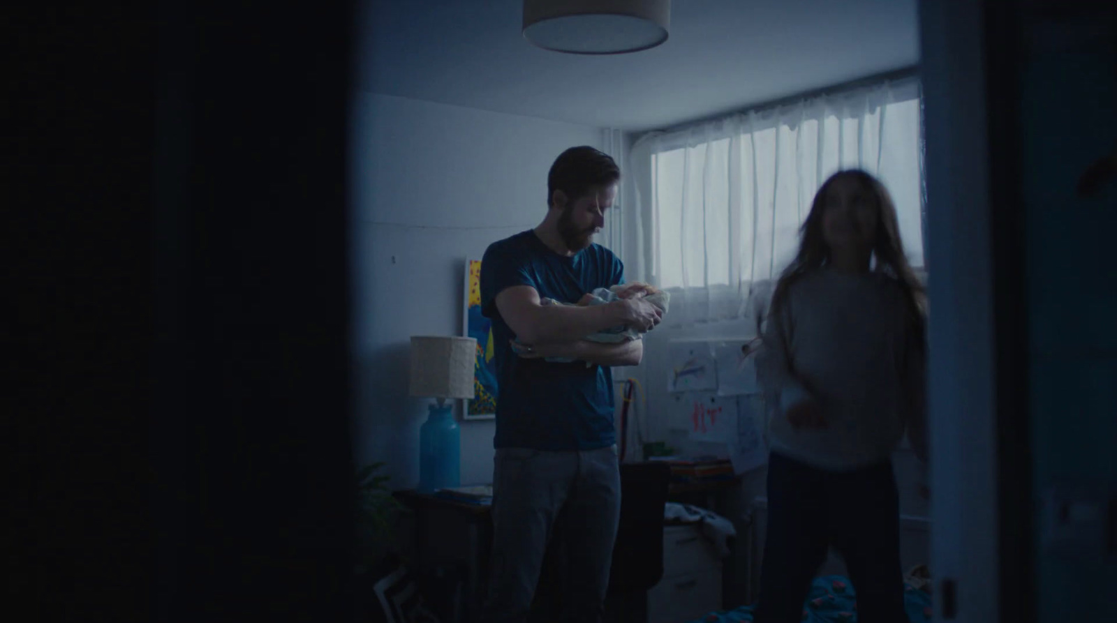 a man and a woman standing in a dark room