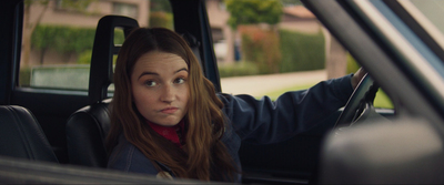 a young woman sitting in a car looking at something