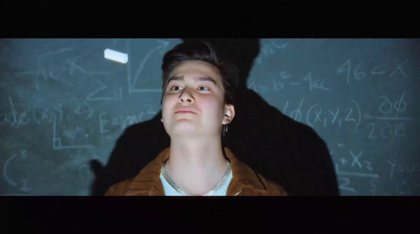 a man standing in front of a blackboard with math written on it