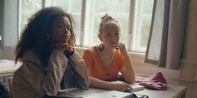 two women sitting at a desk looking at their laptops