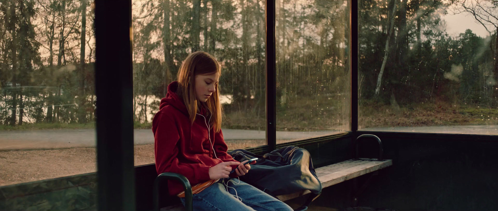 a girl sitting on a bench with a backpack