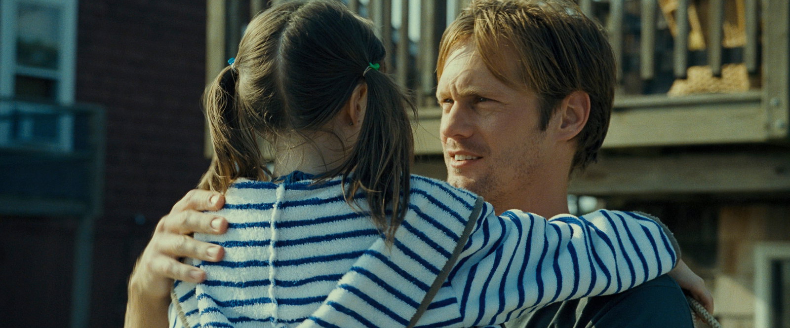 a man hugging a little girl on a porch