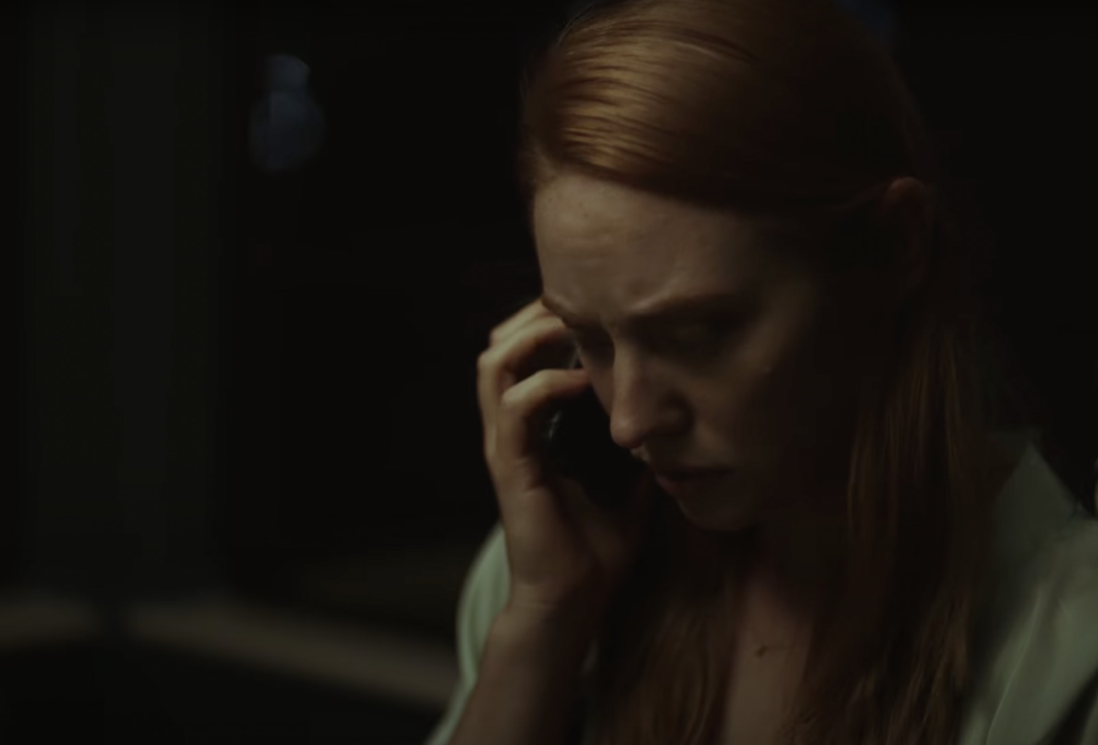 a woman talking on a cell phone in a dark room