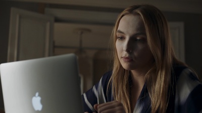 a woman is using an apple laptop in a dark room