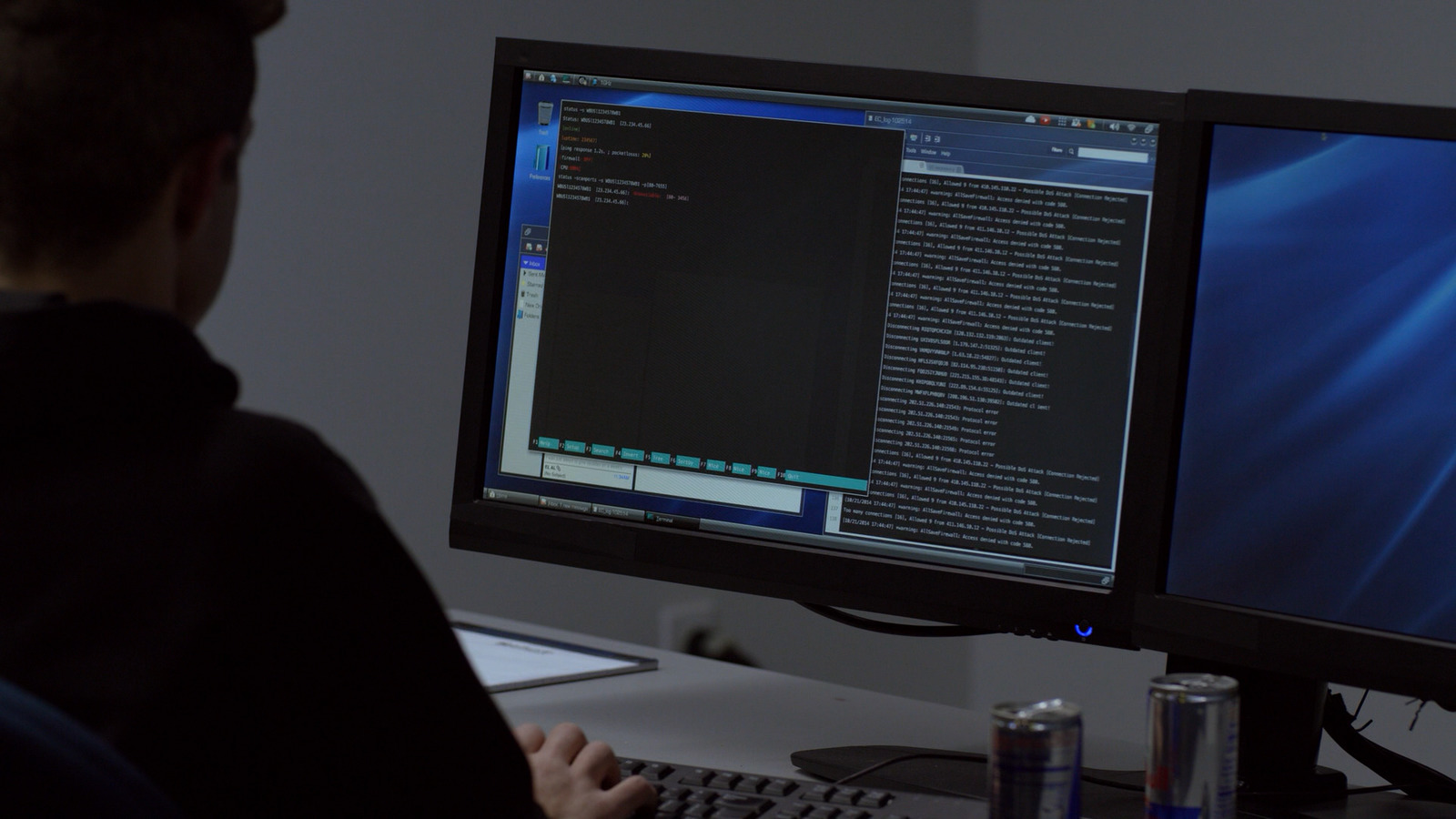 a man sitting at a desk with two computer monitors