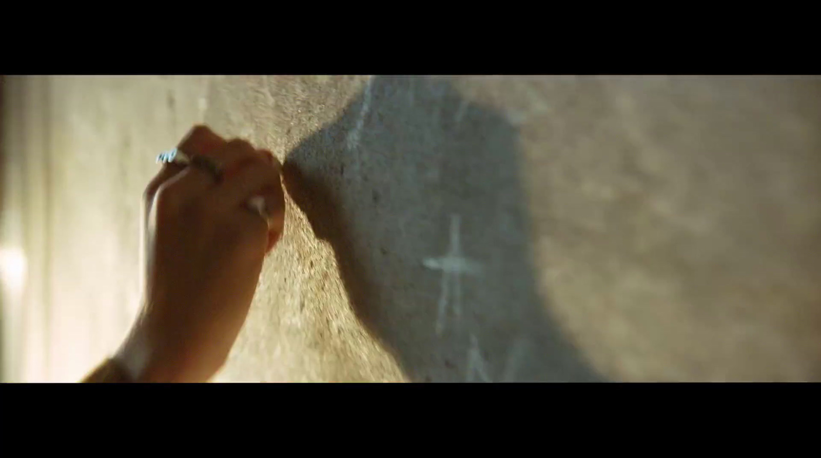 a person writing on a wall with a ring on it