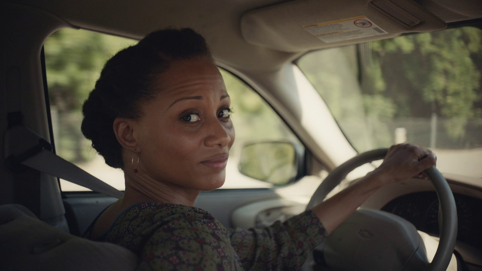 a woman sitting in the driver's seat of a car