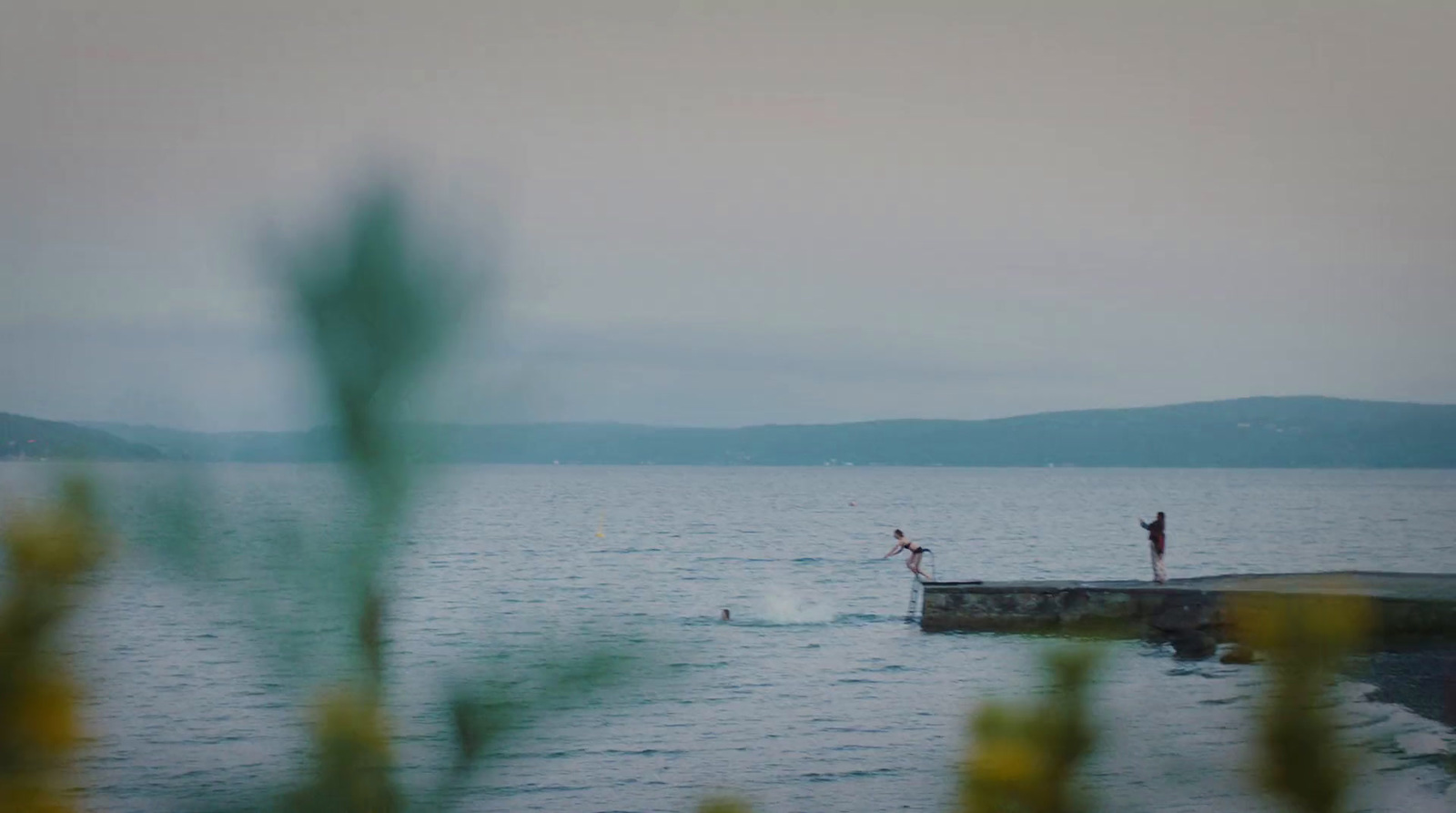 a couple of people standing on top of a body of water