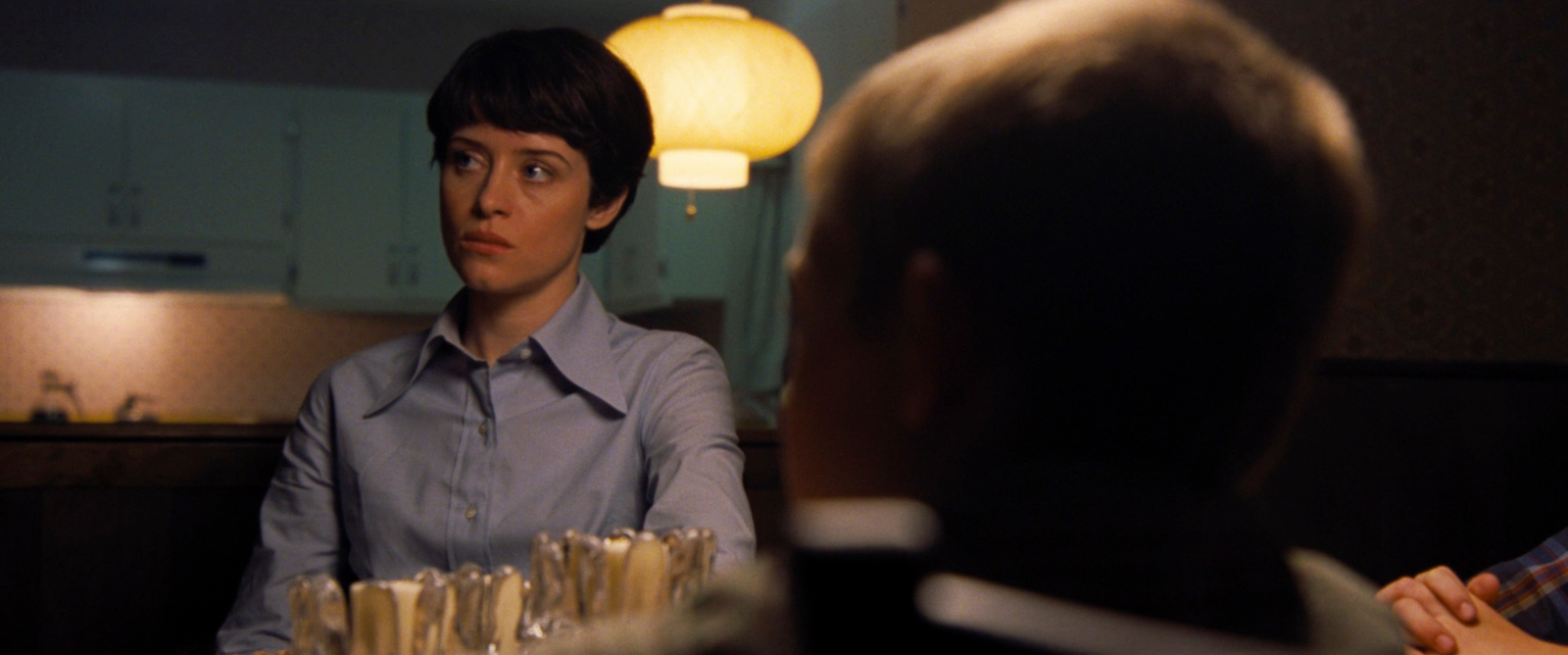 a woman in a blue shirt sitting at a table