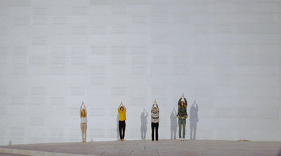 a group of people standing in front of a white wall