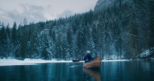 a man in a canoe on a frozen lake