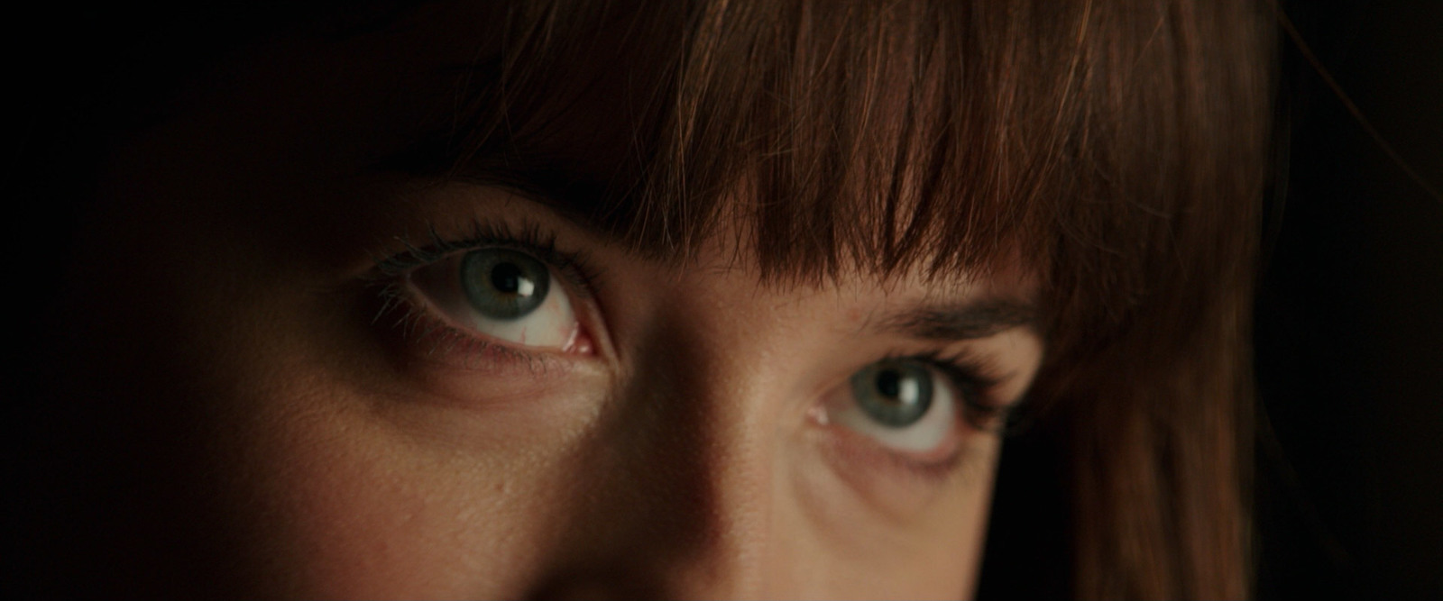 a close up of a woman with blue eyes