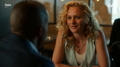 a woman sitting at a table talking to another woman