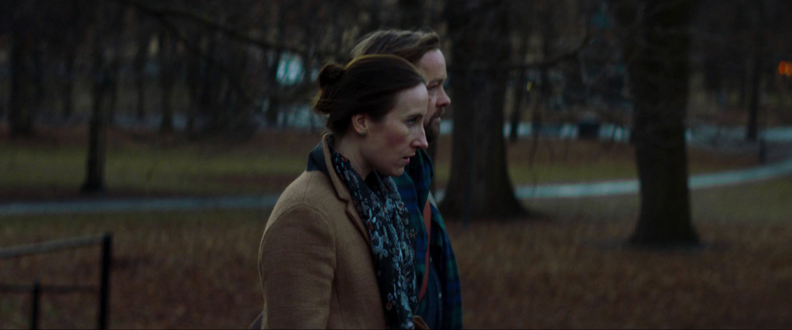 a woman and a man standing in a park