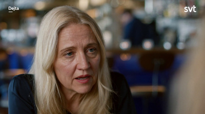 a woman sitting at a table talking to someone