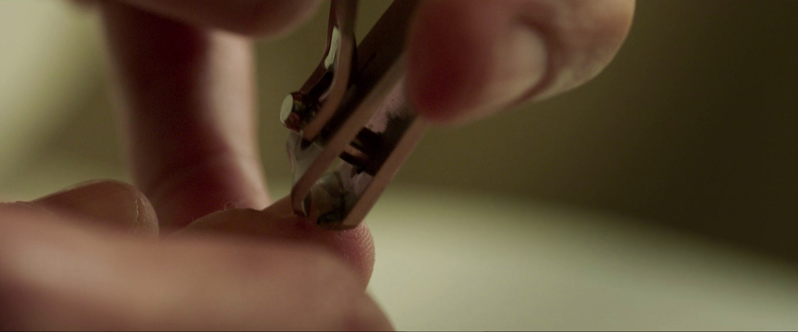 a person cutting a piece of metal with a pair of scissors