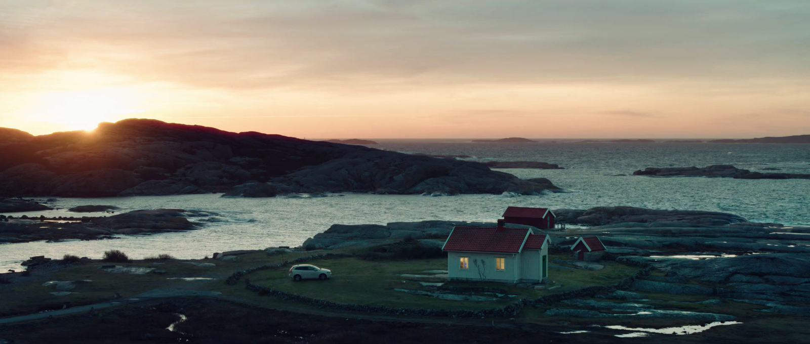 a small house on a rocky island at sunset