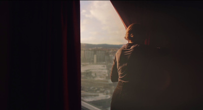 a woman looking out of a window at a city