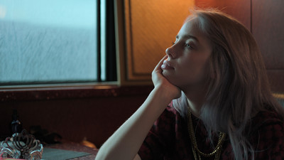 a woman sitting at a table looking at a window