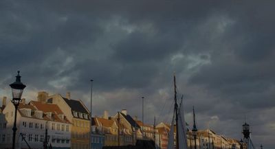 a boat docked in a harbor under a cloudy sky