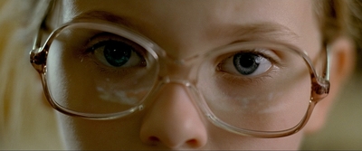 a close up of a young girl wearing glasses